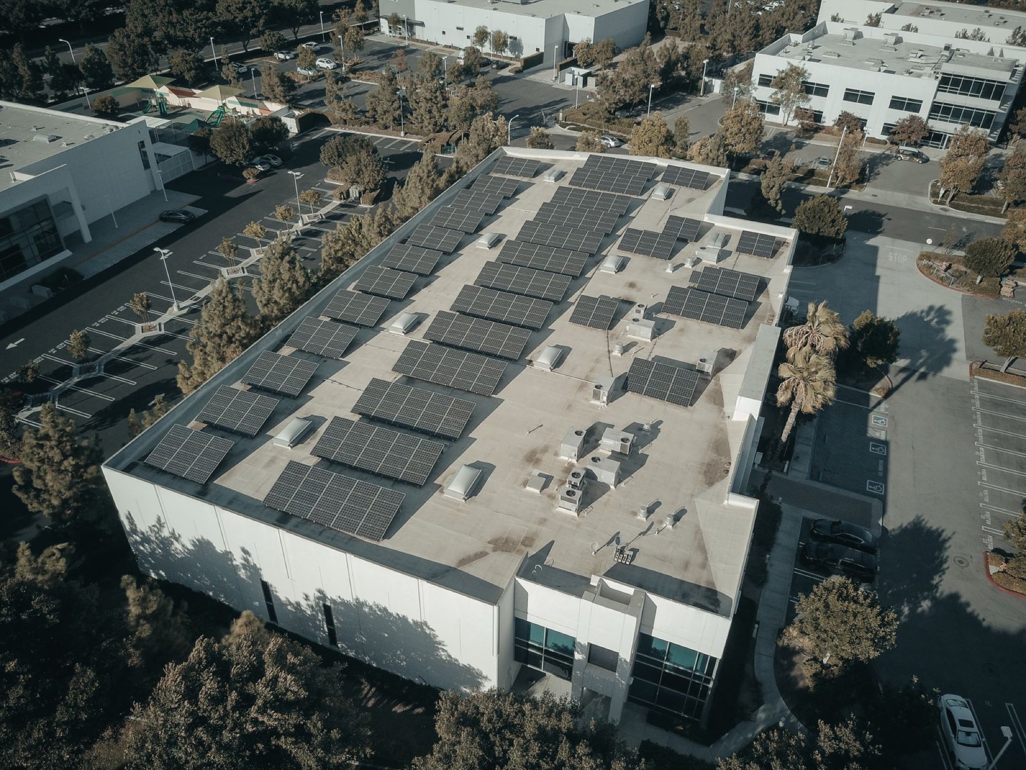 Rooftop solar array covering a commercial building, aerial view