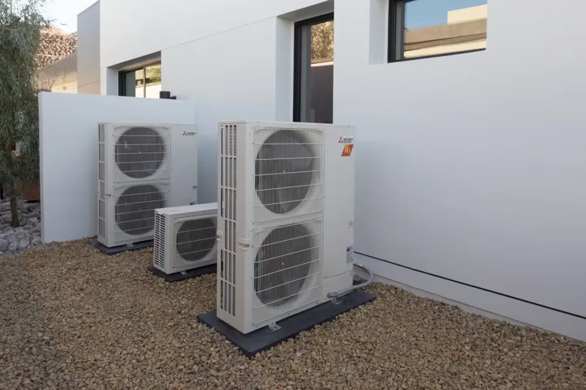 Mitsubishi heat-pump condensers outside a Massachusetts home