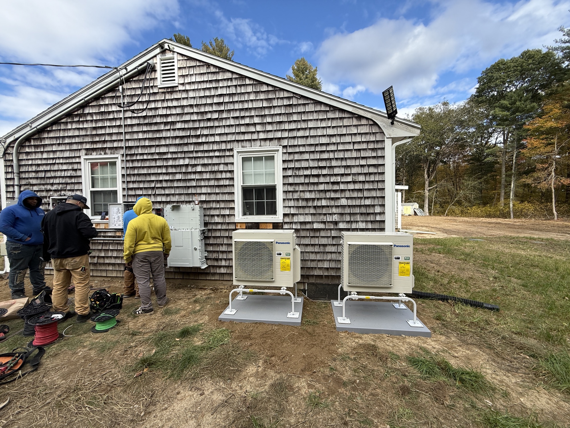 Nexis crew installing Panasonic ductless heat pump condensers at a Massachusetts home